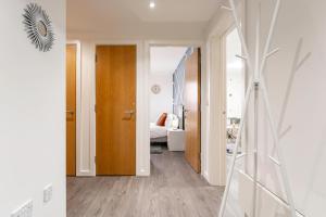 um corredor com uma porta e um quarto com uma cama em JKG Property Solutions Presents Cosy City Apartment em Coventry