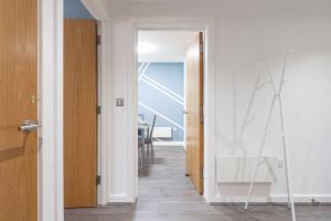 um corredor com uma porta que leva a uma sala de jantar em JKG Property Solutions Presents Cosy City Apartment em Coventry