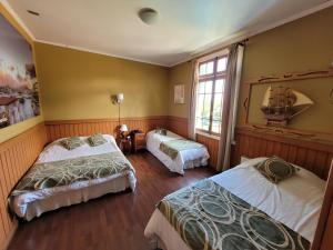una camera da letto con due letti e una finestra di Hotel San Giorgio a Capitán Pastene