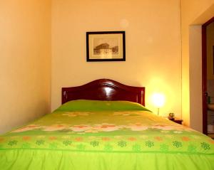 een slaapkamer met een bed met een groen dekbed bij Kanata Properties 2 in Lima