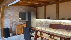 een patio met een houten tafel en stoelen en een koelkast bij Penzion Hedvika in Kravaře