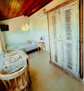 een kamer met een bed en een groot raam bij Encanto das Flores in Pipa
