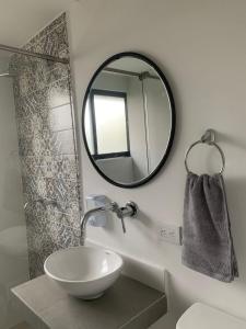 a bathroom with a sink and a mirror at Hotel 14-04 in Cali