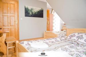 ザコパネにあるSłoneczny Domekのベッドルーム1室(ベッド1台付)、木製のドア