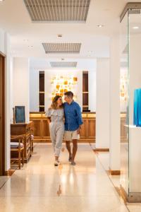 Un uomo e una donna che camminano lungo un corridoio di Art&Park Hotel Union Lido a Cavallino-Treporti Altre 37 foto