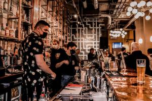 a man standing at a bar with a bartender at REZz Cork in Cork