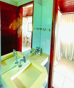 a bathroom with a sink and a mirror at Encanto das Flores in Pipa