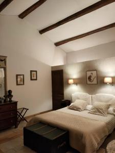a bedroom with a large bed and a dresser at Le Mas d'Hermès in Plan-dʼOrgon