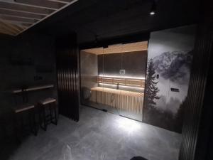 a dark room with a bench and a table and a window at Domki PRemium in Zawoja