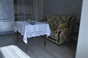 uma mesa e uma cadeira numa sala de estar em Cosy Home em Guiumri
