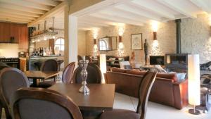 PontlevoyにあるLes Loges de Saint Eloiのソファ、テーブル、椅子が備わるレストラン