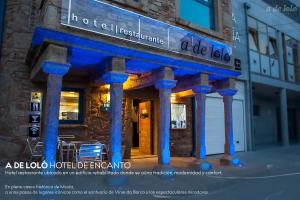 穆希亞的住宿－A de Loló Alojamiento con encanto，建筑前方有蓝色柱子的建筑