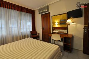 una camera d'albergo con letto e scrivania con specchio di Hotel Aragón a Salamanca