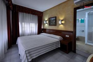 una piccola camera con letto e doccia di Hotel Aragón a Salamanca