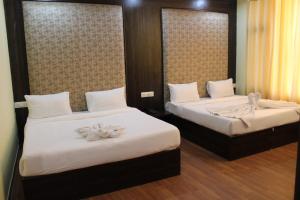 2 Betten in einem Hotelzimmer mit Blumen darauf in der Unterkunft HOTEL THE DIAMOND LEAF in Chandīgarh