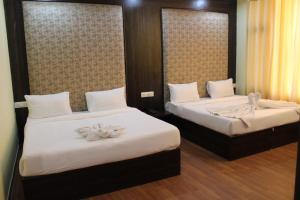 two beds in a hotel room with flowers on them at HOTEL THE DIAMOND LEAF in Chandīgarh