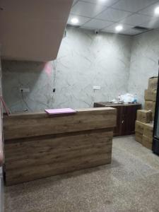 een kantoor met een houten bureau en een marmeren muur bij HOTEL THE DIAMOND LEAF in Chandīgarh