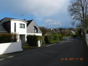 Ein weißes Haus an der Seite einer Straße in der Unterkunft Patras in Ergué-Gabéric