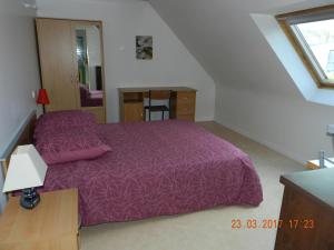 - une chambre avec un lit violet et un escalier dans l'établissement Patras, à Ergué-Gabéric