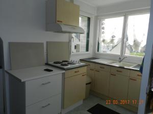 uma pequena cozinha com um fogão e um lavatório em Patras em Ergué-Gabéric