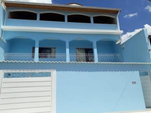 a blue house with a white garage door at Almada Studio 77 in Cunha