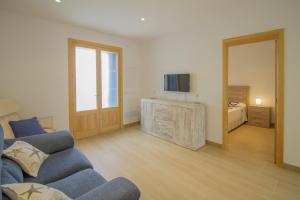 a living room with a couch and a tv and a bed at Casa Nord 50 by Mallorca House Rent in Portocolom