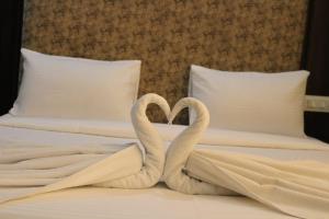 dois cisnes a fazer um coração numa cama em HOTEL THE DIAMOND LEAF em Chandīgarh