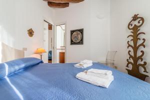 威尼斯的住宿－威尼斯七窗旅館，一间卧室配有蓝色的床和毛巾