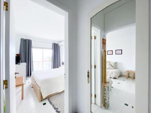 Dormitorio blanco con espejo y cama en Casa Nós e o Mar - 3 minutos a pé da praia, en Lagos
