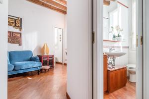 ein Badezimmer mit einem blauen Sofa und einem Waschbecken in der Unterkunft 7 WINDOWS ON VENICE in Venedig