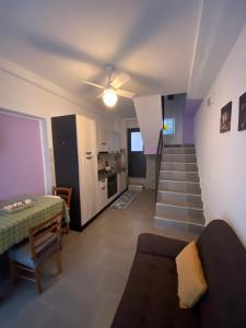 a living room with a staircase and a couch and a kitchen at B&B Casetta Verde FELICE in Scilla