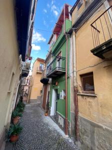 un callejón estrecho con edificios verdes y amarillos en B&B Casetta Verde FELICE, en Scilla