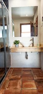 ein Badezimmer mit Waschbecken und Spiegel in der Unterkunft Casas Rurales en Peguerinos (P.N. del Guadarrama) in Peguerinos