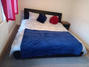 a blue and white bed with a red ball on it at Immaculate 3 bedroom property. in Nottingham