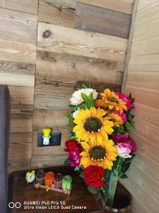 un jarrón de flores en una mesa junto a una pared en Cabanuta din munti, en Moieciu de Jos