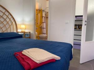 a bedroom with a blue bed with a red towel on it at B&B Casetta Verde FELICE in Scilla