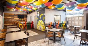 a restaurant with tables and chairs under colorful umbrellas at Hostal CASA MX centro in Mexico City