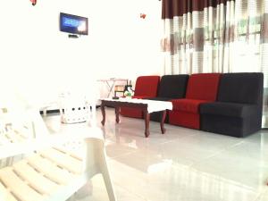 a living room with a red couch and a coffee table at Mango Villa in Hikkaduwa