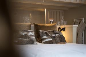a bed with a blanket and pillows on top of it at Hôtel Restaurant La Ferme de Cupelin in Saint-Gervais-les-Bains