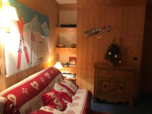 a living room with a couch and a christmas tree at Le Mottet -Prariond - ESF & Skis aux pieds in Valmorel