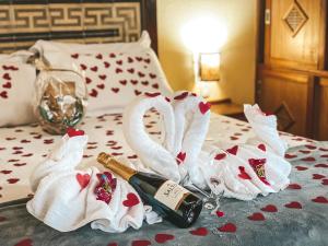 dwa łabędzie z butelką szampana na łóżku w obiekcie Pousada Espelho Dagua w mieście Gonçalves