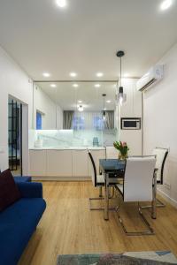 ein Wohnzimmer mit einem Tisch und einem blauen Sofa in der Unterkunft Moder Chic Apartment in Center-PRIME RENTALS in Kaunas