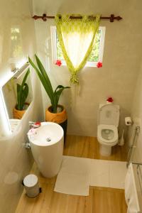 a bathroom with a sink and a toilet and a window at Villa Charette-Self Catering Villas in La Digue