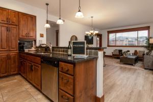 a kitchen with wooden cabinets and a counter top at Modern Riverstone Condo with Grand Deck - Steps to Shops, Restaurants & Trail in Coeur d'Alene