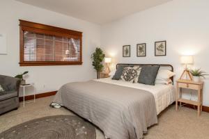 a bedroom with a large bed and a window at Modern Riverstone Condo with Grand Deck - Steps to Shops, Restaurants, Trails and River in Coeur d'Alene +14 photos