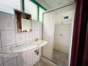 a white bathroom with a sink and a shower at Hotel La Cascada in Puntarenas