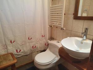 ein Badezimmer mit einer weißen Toilette und einem Waschbecken in der Unterkunft Casa verano piscina Villarrica in Villarrica + 32 Fotos