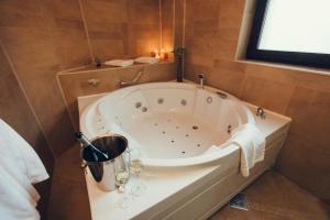 a bathroom with a tub with wine glasses in it at Denisa Boutique in Poiana Brasov