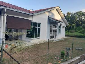 una casa con una valla delante de ella en Rumah Armand Ayer Keroh Bandar Melaka 4BR Fully Aircond, en Melaka