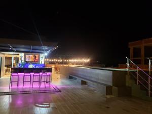 una fila de sillas púrpuras en un escenario por la noche en Tuareg Suite Deluxe, en Santa Cruz de la Sierra